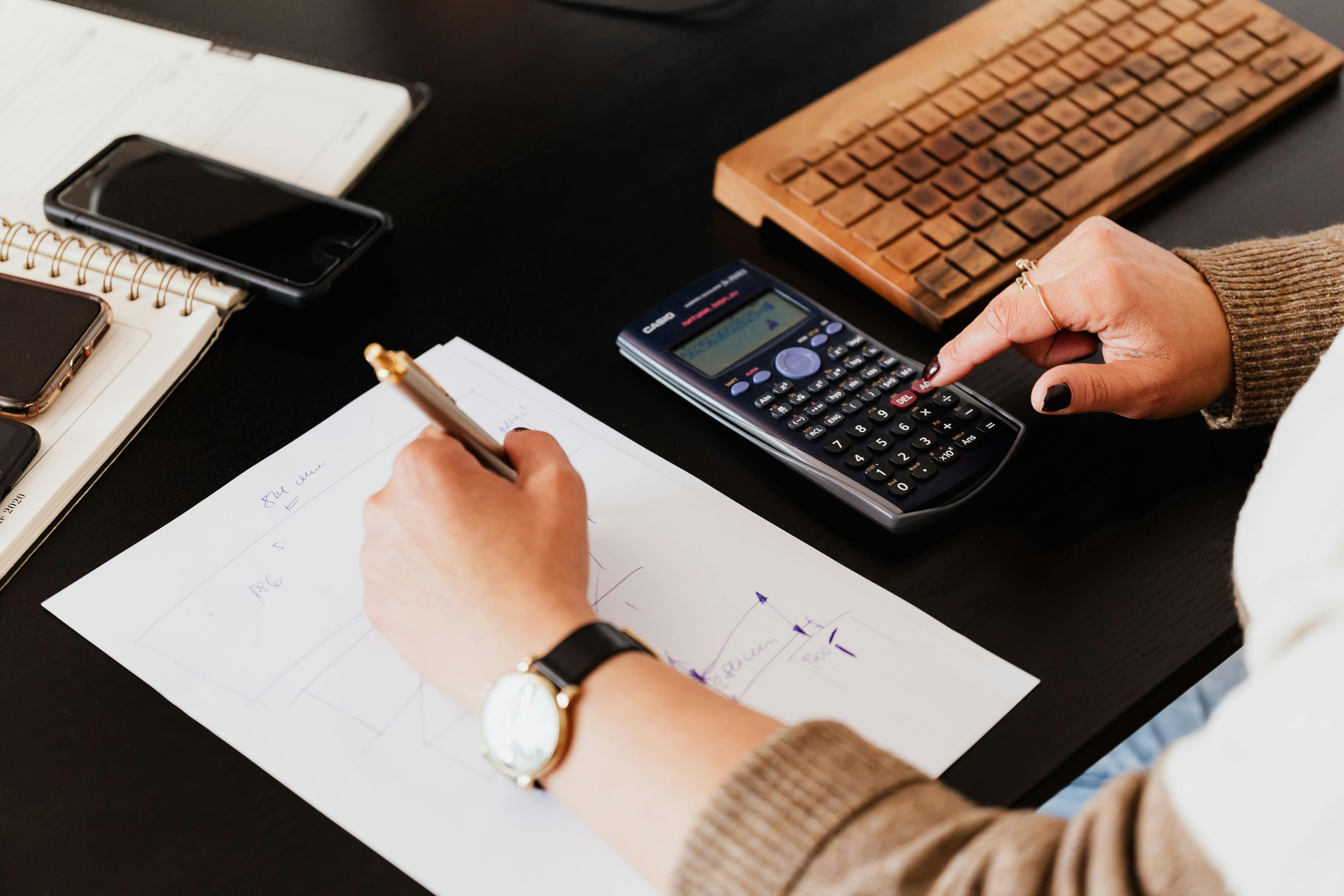 Calculs comptables réalisés à la main avec une calculatrice